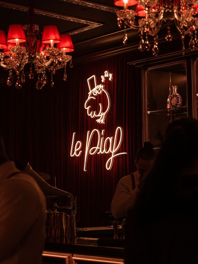 The Le Piaf neon and the piano at Le Piaf Dubai